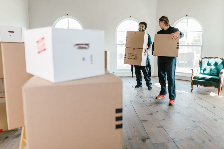Movers loading a padded freight elevator with furniture in a Houston apartment building
